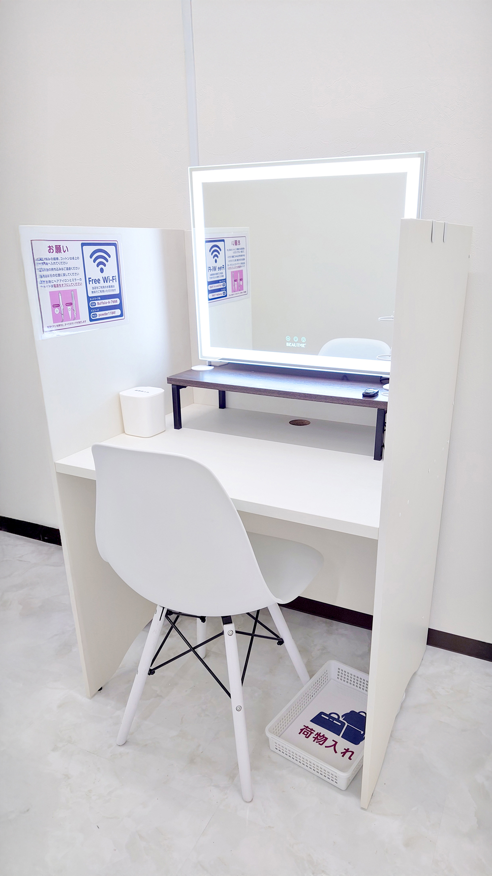 ホワイトカラーでまとめられたシンプルなパウダーブース。足元に荷物入れカゴを設置。